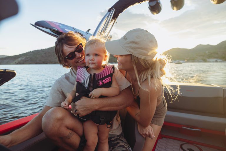 A family show their little girl what it looks like to drive a boat.