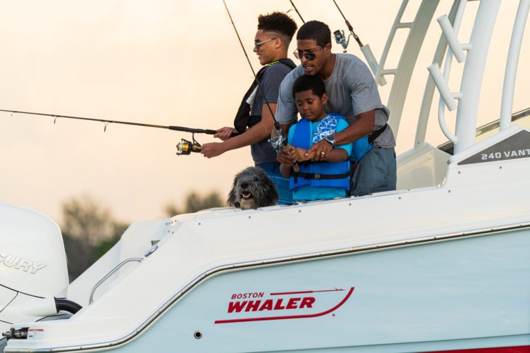 A family fishes on the side of a Boston Whaler