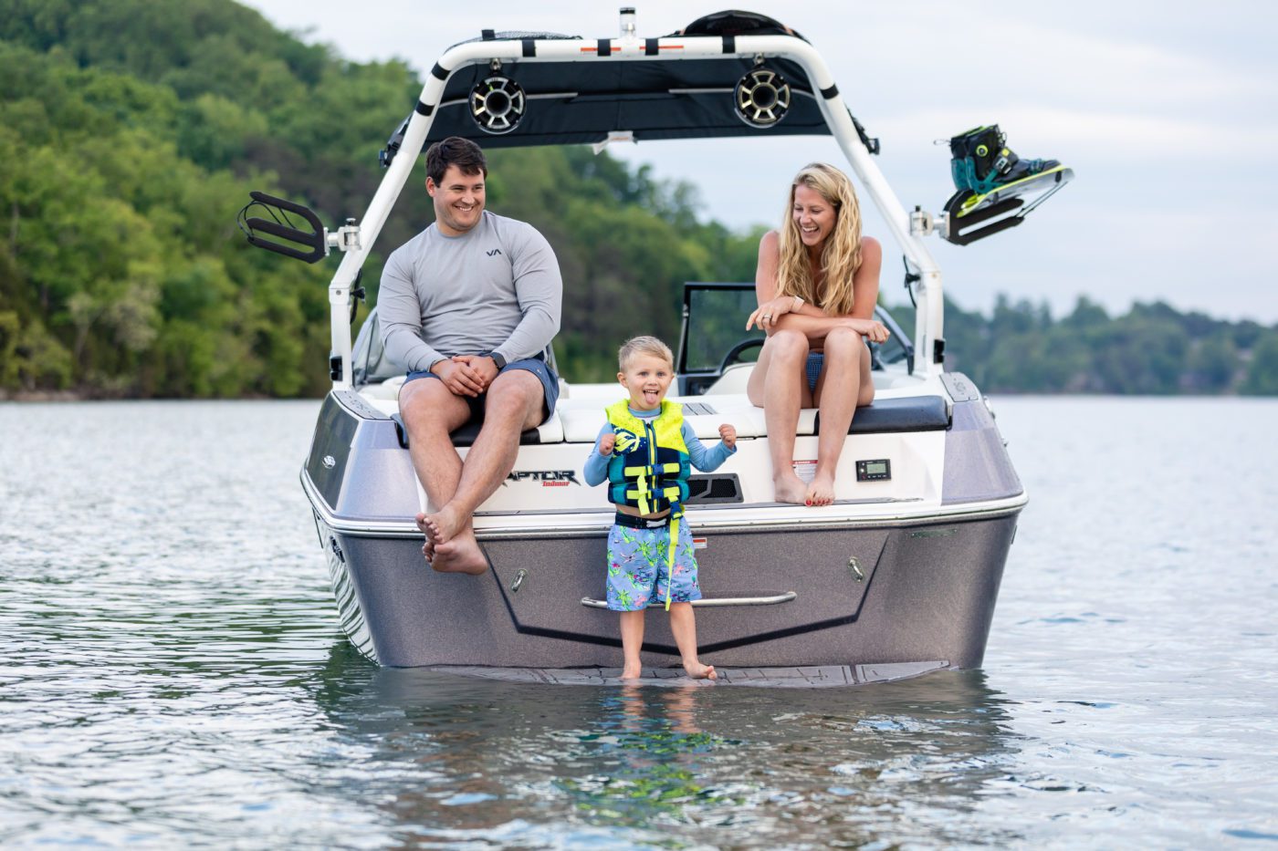 A family sitting on a Moomba at the lake.