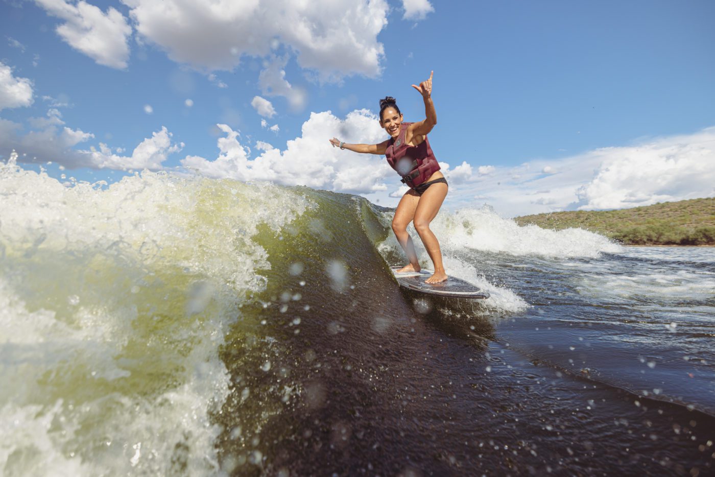 Woman surfing perfect waves from a MasterCraft.