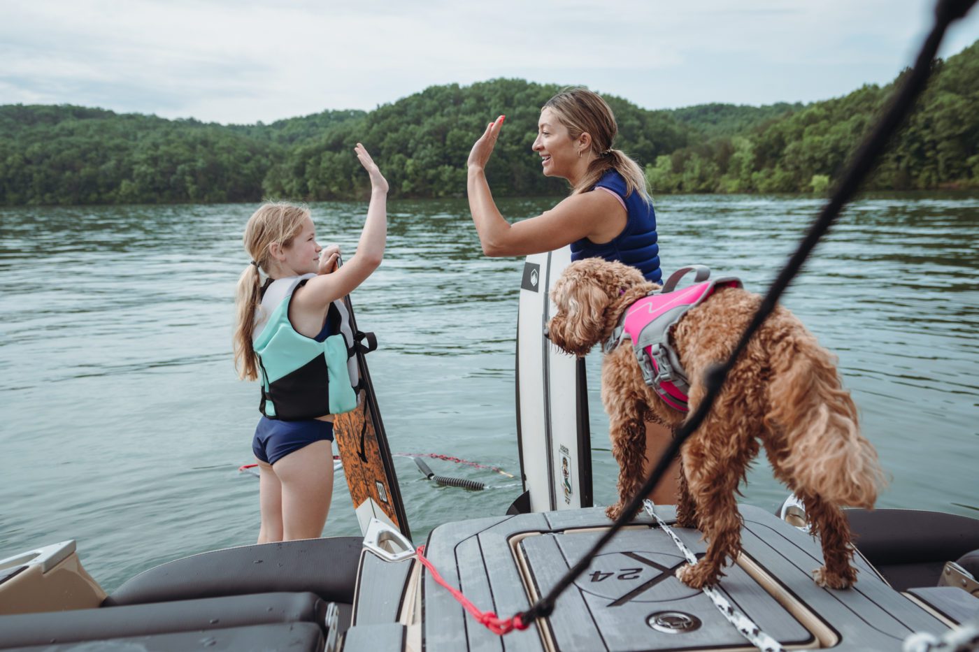 A mother and daughter high five on a MasterCraft wake boat
