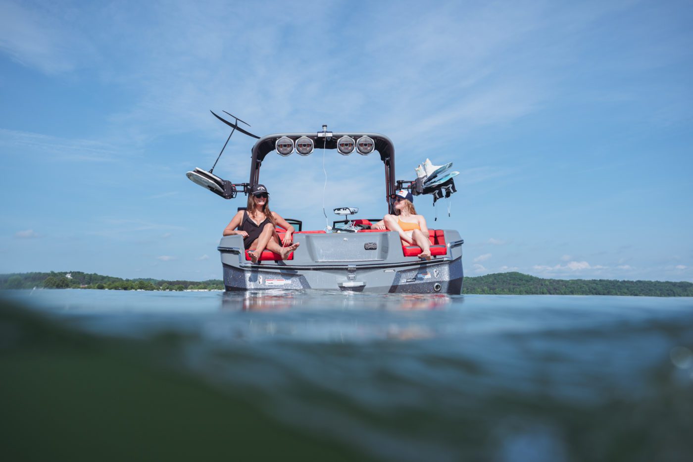 A family enjoys the day on the water in a wake boat.