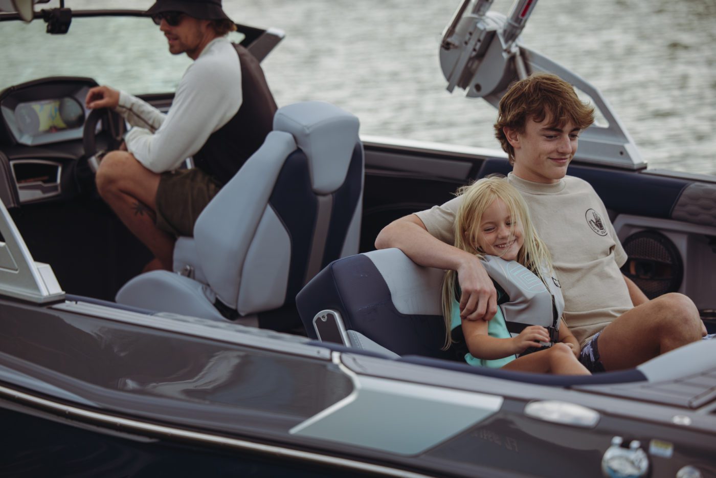 A big brother sits next to his little sister in a MasterCraft