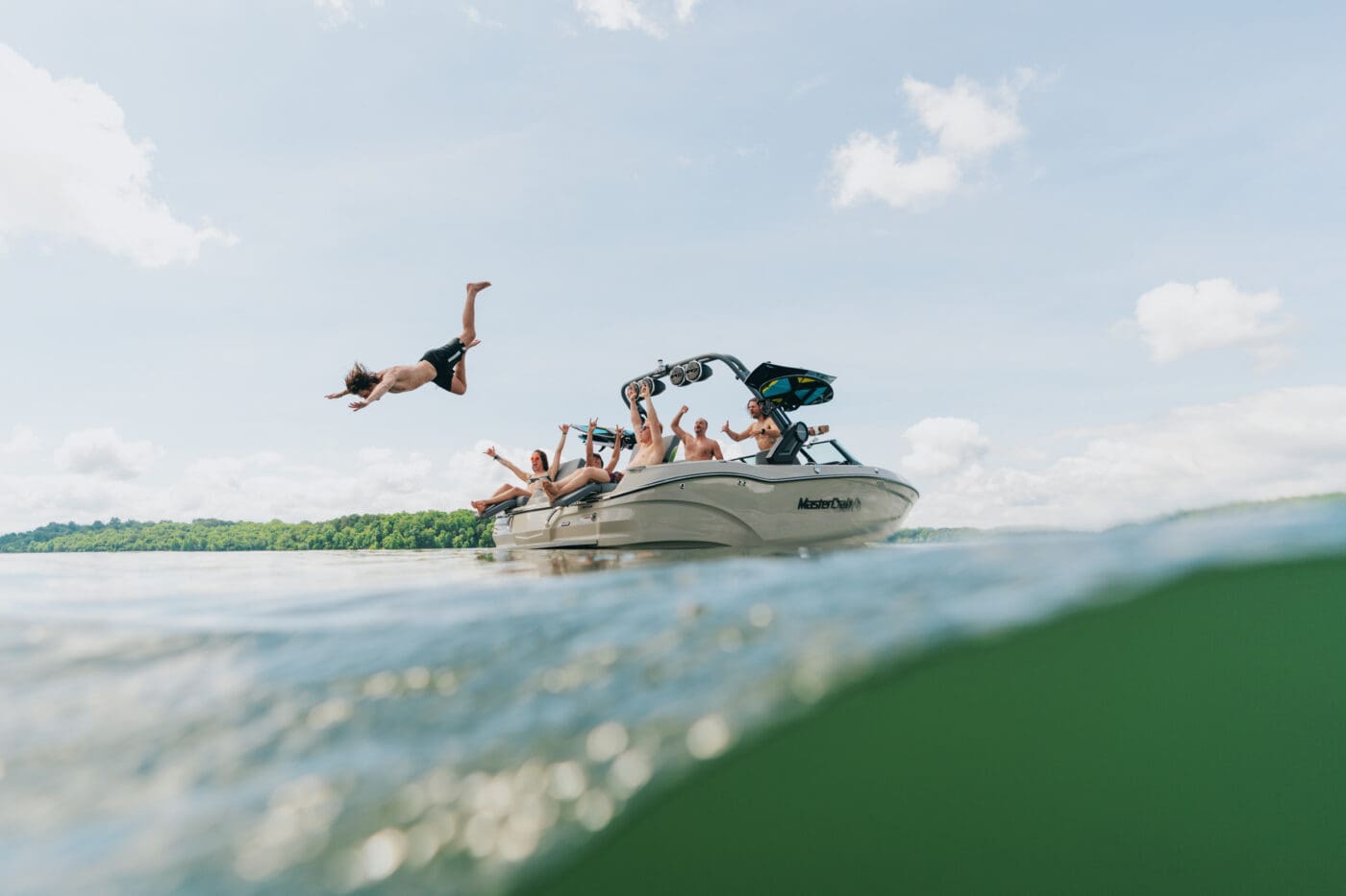 A boater jumping off of a 2025 MasterCraft X22 wake boat.