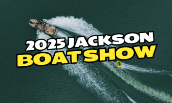 A MasterCraft pulling a tuber with a Boat Show banner over it.