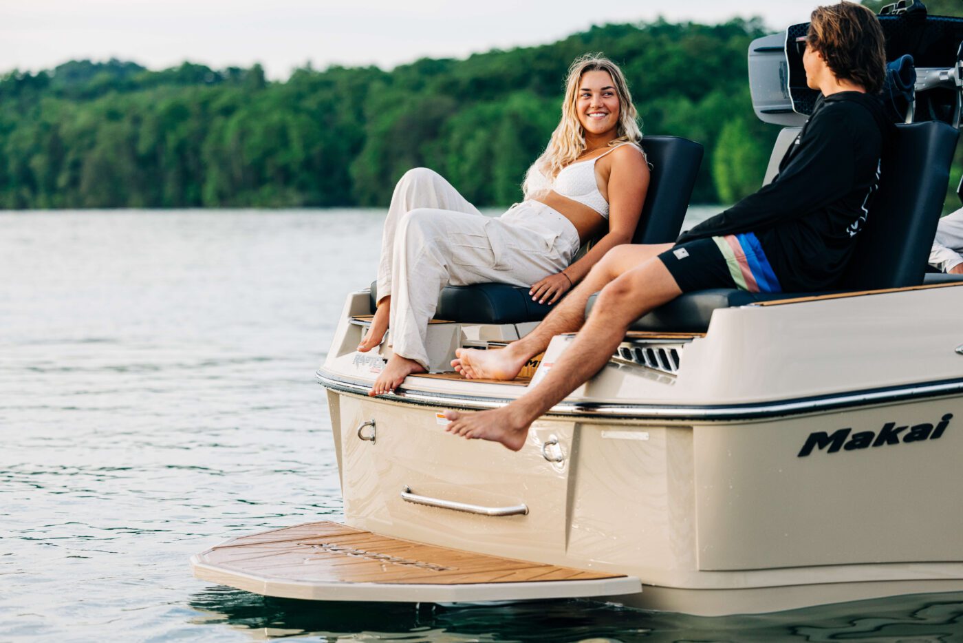 A couple relax on the transom of a new Moomba boat