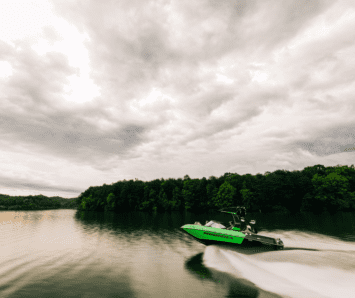 A green wake boat hits the open water.