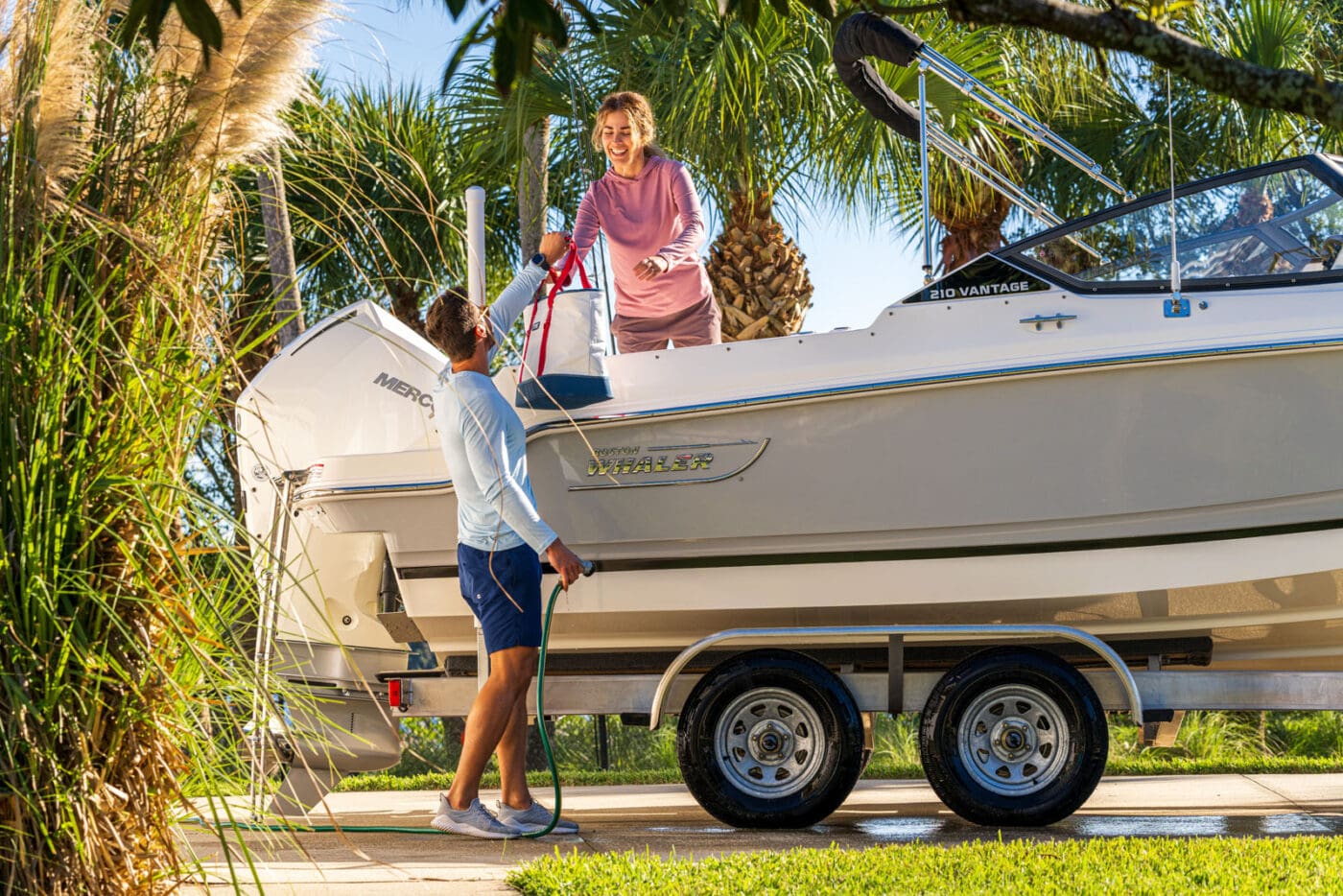 A man helps his wife load their Boston Whaler 210 Vantage.