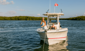 A woman anchoring a Boston Whaler 250 Outrage in the lake.