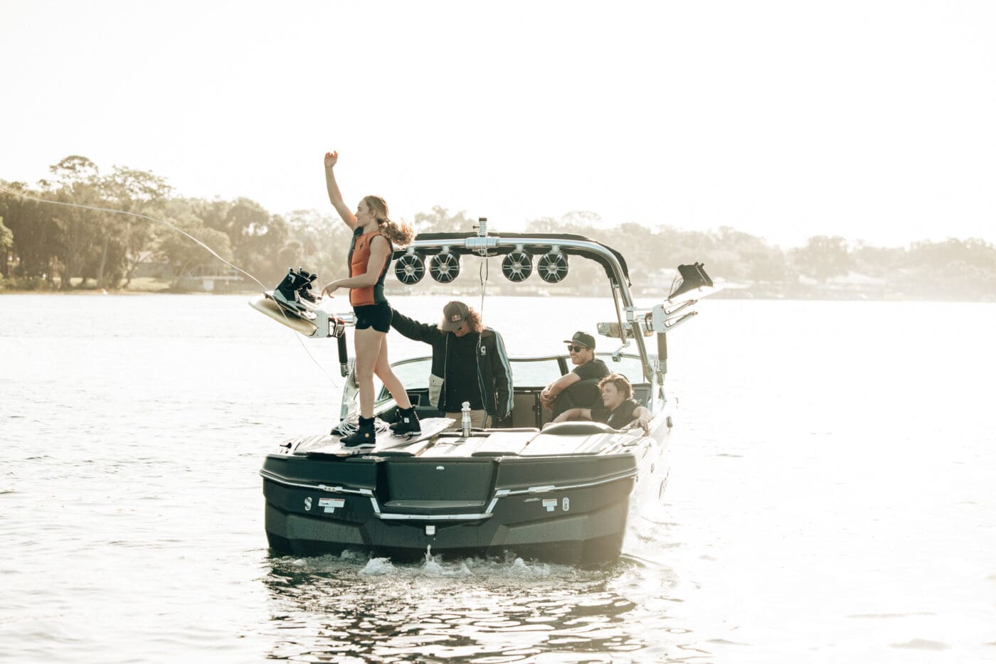 A girl throws a wake rope into the water before she wake boards.