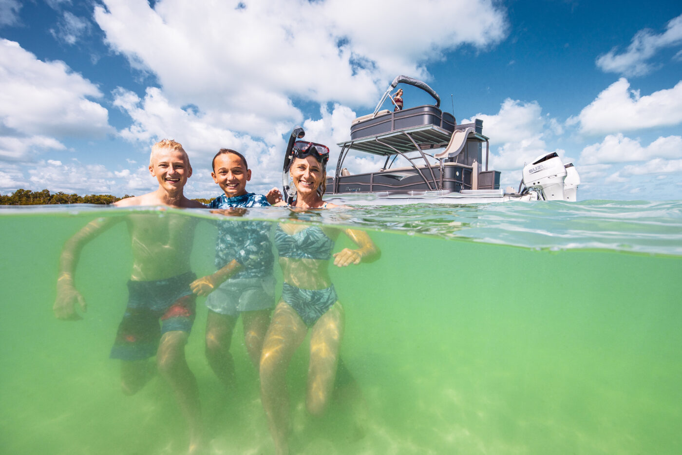 Friends pose for a picture in front of a Premier Pontoons