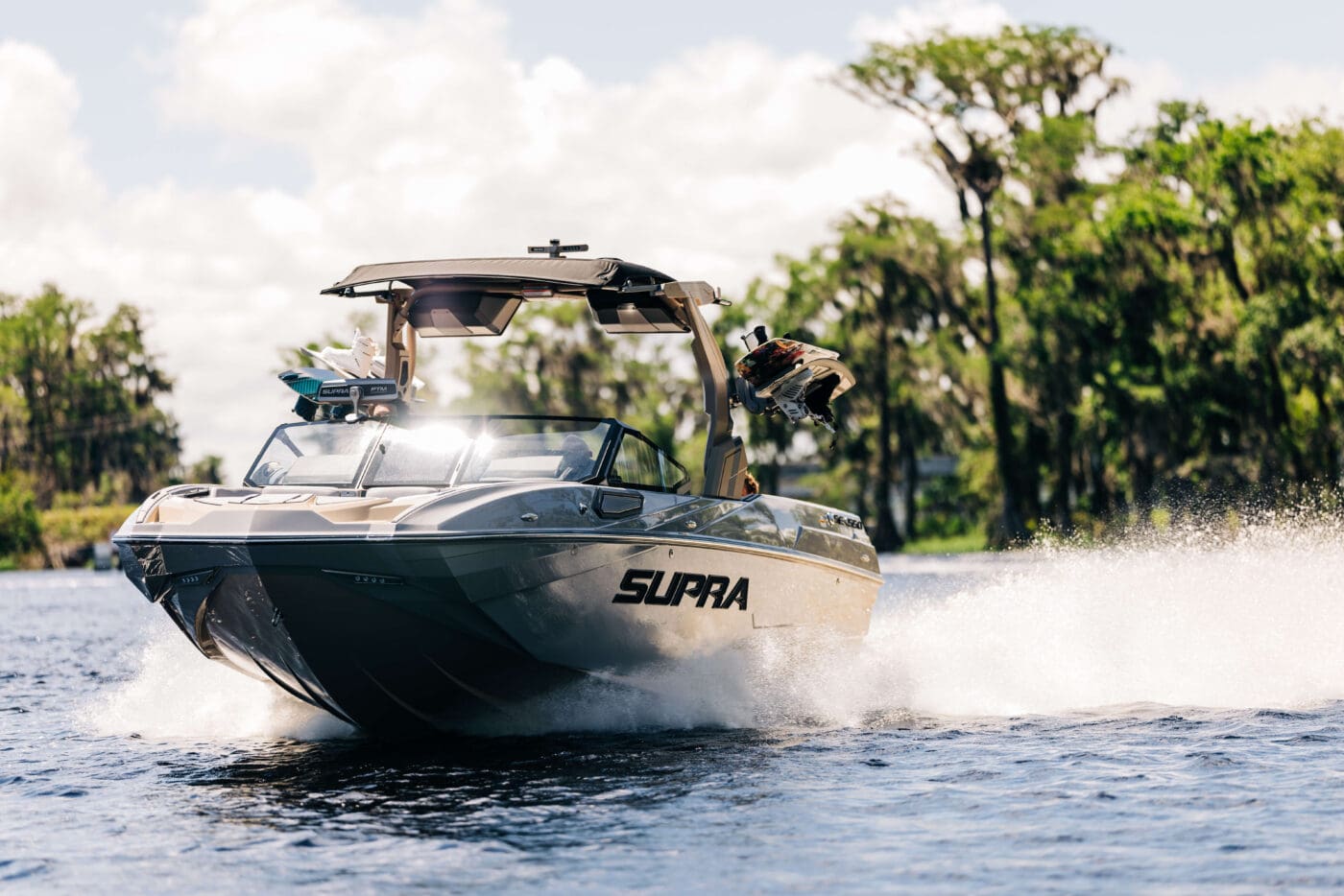 A 2024 Supra SE driving through the lake.