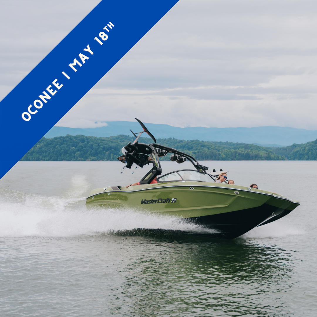 A green MasterCraft model running across the water.