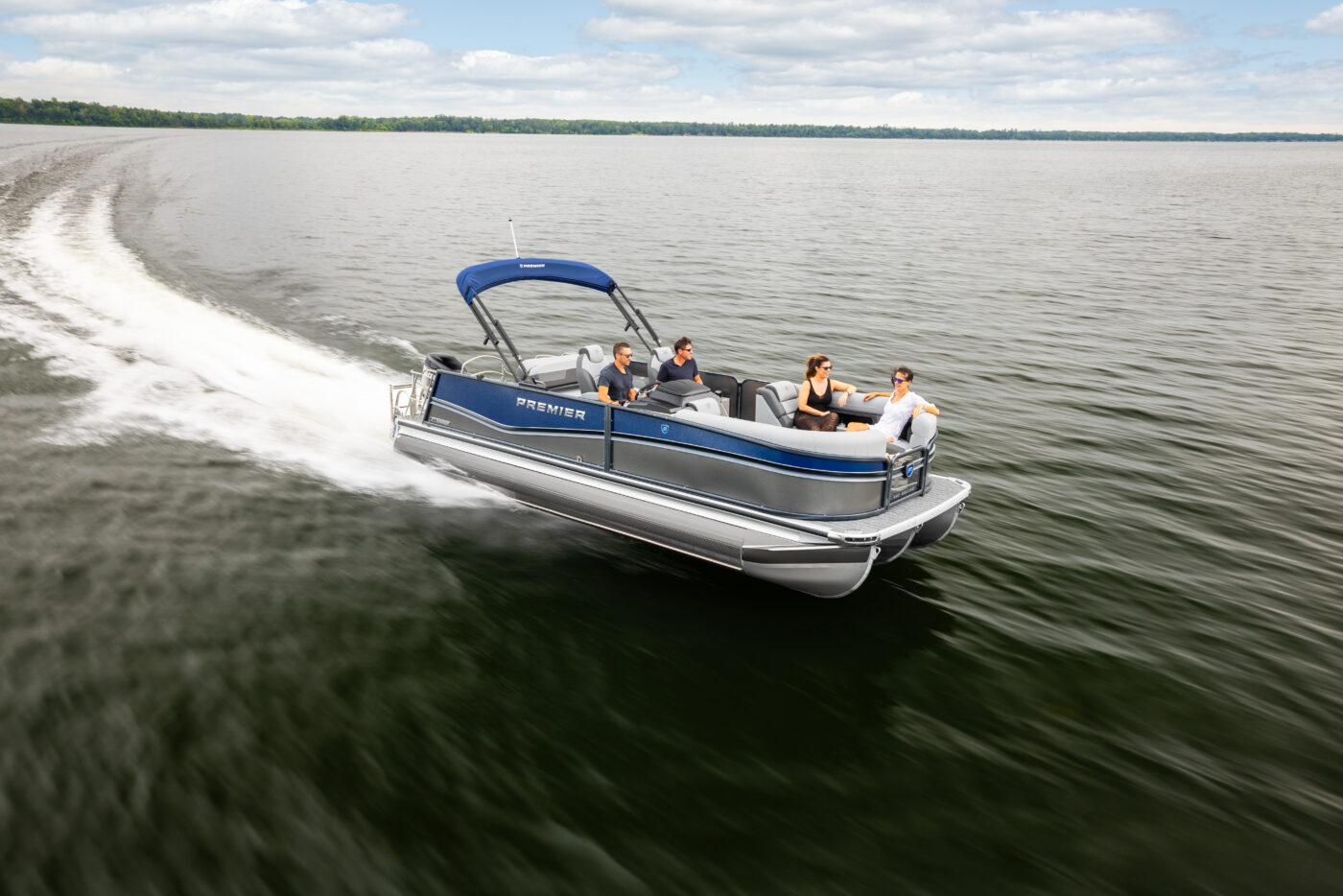 A Premier Pontoon cutting across the lake with a group of friends and family aboard.