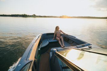 A woman sitting on the bow of a MasterCraft wake boat.