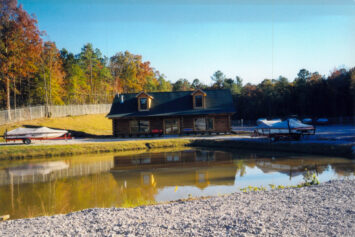 A ski boat dealer lot with a pond.