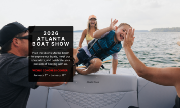 A young boy gets out of the water and high fives a family member on a MasterCraft.